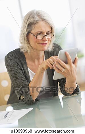 Stock Photo - Senior woman working from home. Fotosearch