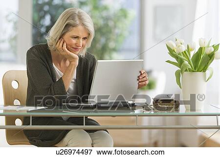 Senior woman working from home View Large Photo Image Stock Photo - Senior woman working from home. Fotosearch