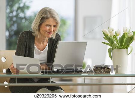 Stock Photography - Senior woman working from home. Fotosearch