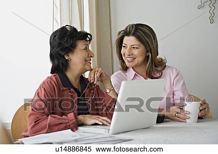 Stock Photography - Senior women using laptop at home. Fotosearch
