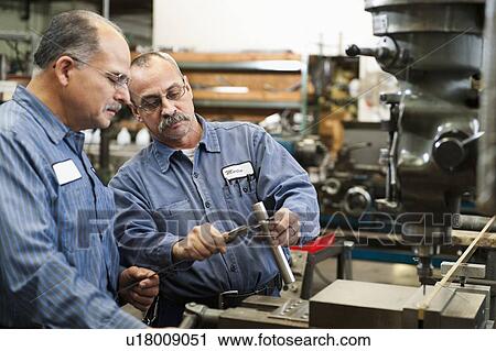 Stock Image - Skilled workers in factory. Fotosearch