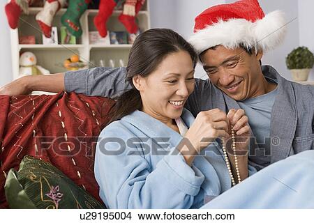 Smiling couple at Christmas morning View Large Photo Image Picture - Smiling couple at Christmas morning. Fotosearch