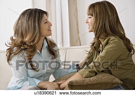 Stock Image - Smiling mother and daughter talking. Fotosearch