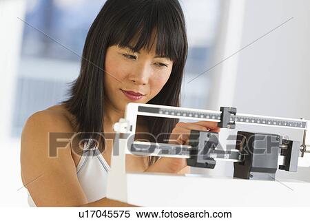 Smiling woman checking her weight View Large Photo Image Stock Photography - Smiling woman checking her weight. Fotosearch