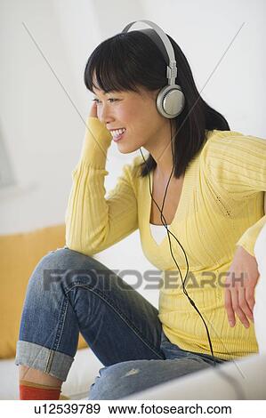 Stock Photo - Smiling woman listening music. Fotosearch