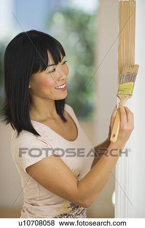 Smiling woman painting door frame View Large Photo Image Stock Photo - Smiling woman painting door frame. Fotosearch