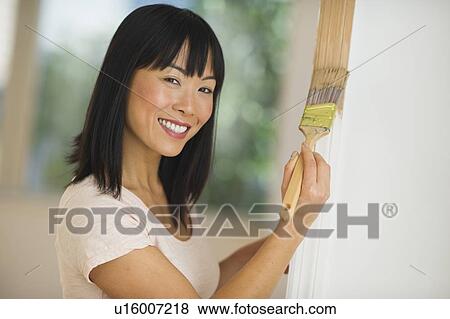 Smiling woman painting door frame View Large Photo Image Stock Photo - Smiling woman painting door frame. Fotosearch