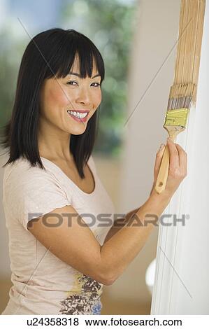 Smiling woman painting door frame View Large Photo Image Stock Photo - Smiling woman painting door frame. Fotosearch