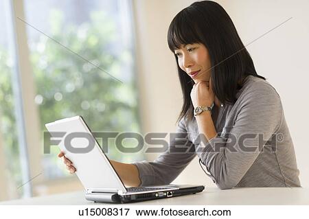 Smiling woman using laptop View Large Photo Image Stock Photo - Smiling woman using laptop. Fotosearch