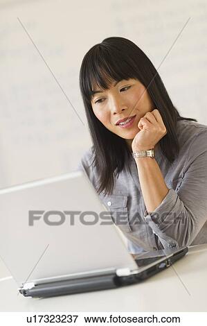 Smiling woman using laptop View Large Photo Image Stock Photo - Smiling woman using laptop. Fotosearch