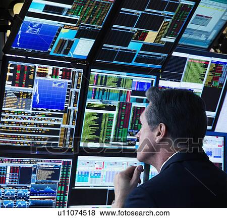 Stock Photo - Stock trader working on computer. Fotosearch
