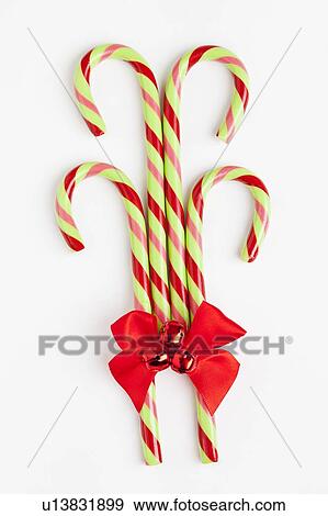 Stock Photo - Striped candy canes with red ribbon, studio shot. Fotosearch