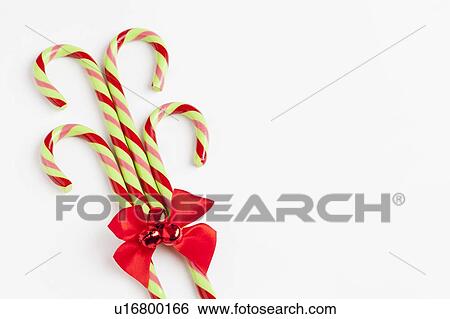 Stock Photograph - Striped candy canes with red ribbon, studio shot. Fotosearch