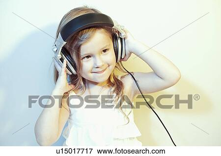 Studio portrait of girl (4-5) listening to music on headphones View Large Photo Image Stock Photo - Studio portrait of girl (4-5) listening to music on headphones. Fotosearch
