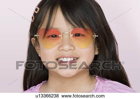 Studio portrait of girl wearing heart-shaped glasses View Large Photo Image Stock Photo - Studio portrait of girl wearing heart-shaped glasses. Fotosearch