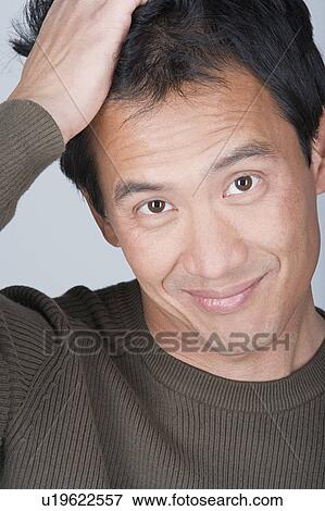 Stock Photo - Studio portrait of happy Asian man. Fotosearch