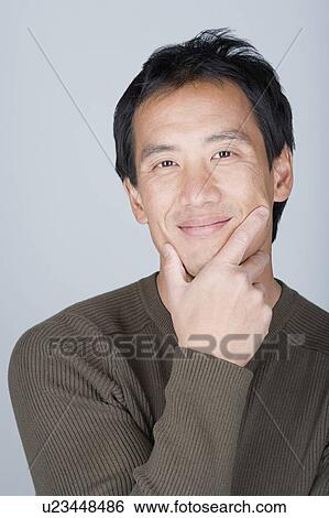 Stock Photograph - Studio portrait of happy Asian man. Fotosearch