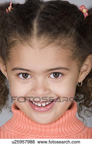 Stock Photo - Studio portrait of happy pre-teen girl (10-11). Fotosearch