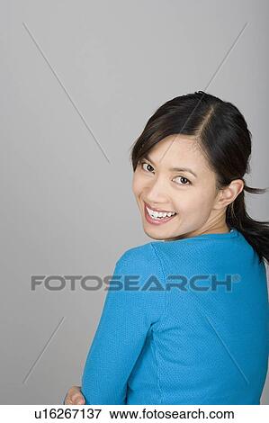 Stock Photo - Studio portrait of happy Vietnamese woman. Fotosearch
