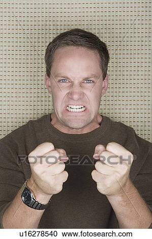 Studio portrait of mature man clenching teeth and fists View Large Photo Image Stock Image - Studio portrait of mature man clenching teeth and fists. Fotosearch