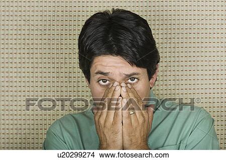 Picture - Studio portrait of mature man covering mouth with hands. Fotosearch