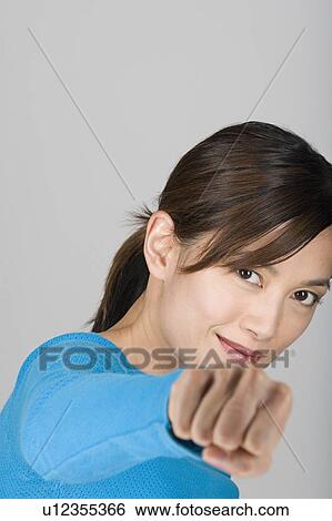 Stock Photograph - Studio portrait of playful Asian woman. Fotosearch