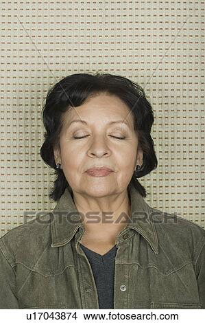 Picture - Studio portrait of senior woman with eyes closed. Fotosearch