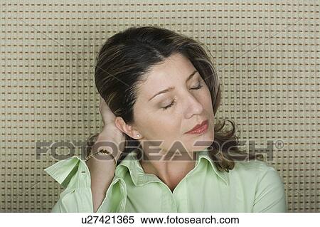 Stock Photography - Studio portrait of senior woman with hand in hair. Fotosearch