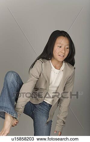 Studio portrait of teen (16-17) girl standing on one leg View Large Photo Image Stock Image - Studio portrait of teen (16-17) girl standing on one leg. Fotosearch