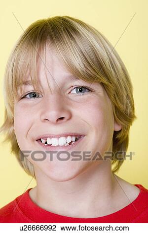 Stock Image - Studio portrait of teenage (16-17) boy smiling. Fotosearch