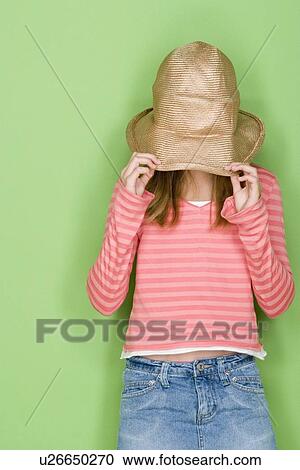 Studio portrait of teenage (16-17) girl covering face with hat View Large Photo Image Stock Image - Studio portrait of teenage (16-17) girl covering face with hat. Fotosearch