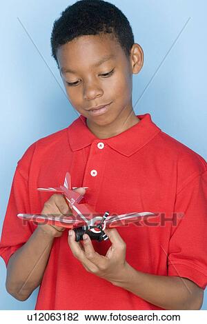 Studio portrait of teenage boy holding toy plane View Large Photo Image Stock Image - Studio portrait of teenage boy holding toy plane. Fotosearch