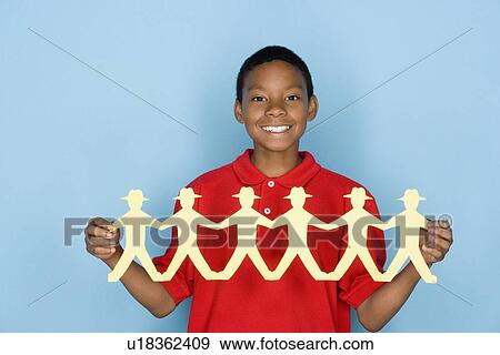 Studio portrait of teenage boy holding paper cutout View Large Photo Image Stock Photo - Studio portrait of teenage boy holding paper cutout. Fotosearch
