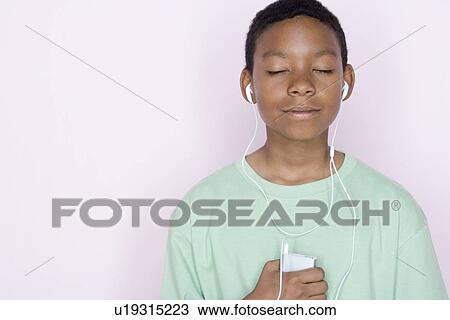 Studio portrait of teenage boy listening to music View Large Photo Image Stock Image - Studio portrait of teenage boy listening to music. Fotosearch