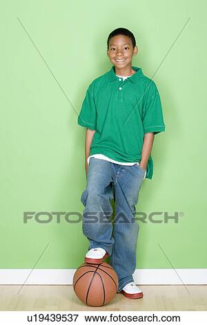 Stock Photo - Studio portrait of teenage boy with basketball. Fotosearch