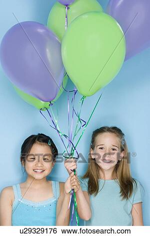 Studio portrait of two teenage (16-17) girls holding balloons View Large Photo Image Stock Photograph - Studio portrait of two teenage (16-17) girls holding balloons. Fotosearch