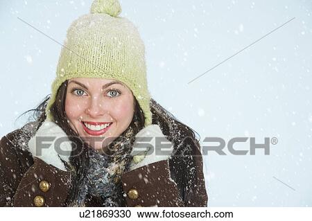 Stock Image - Studio portrait of woman in winter clothing. Fotosearch