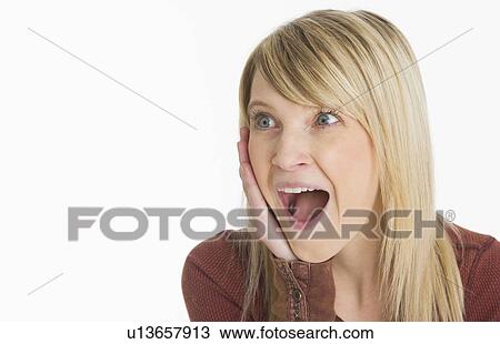 Stock Image - Studio portrait of woman looking surprised. Fotosearch