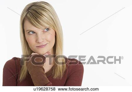 Stock Photo - Studio portrait of woman with hand on chin. Fotosearch