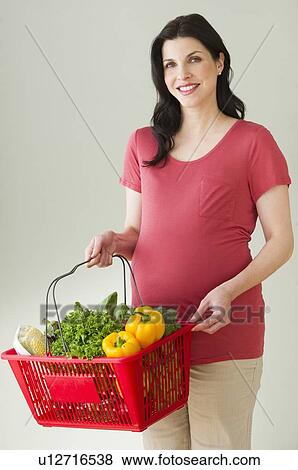 Studio portrait of woman with shopping basket full of groceries View Large Photo Image Stock Photo - Studio portrait of woman with shopping basket full of groceries. Fotosearch
