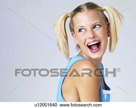 Stock Image - Studio portrait of young woman laughing. Fotosearch