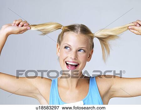Studio portrait of young woman with hand in hair View Large Photo Image Stock Photo - Studio portrait of young woman with hand in hair. Fotosearch