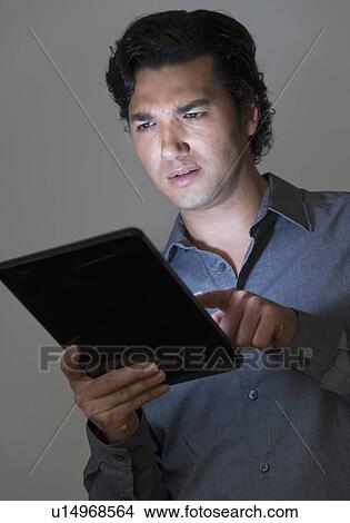 Picture - Studio shot of businessman using digital tablet. Fotosearch
