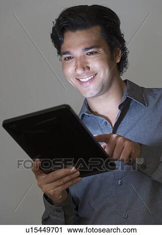 Studio shot of businessman using digital tablet View Large Photo Image Stock Image - Studio shot of businessman using digital tablet. Fotosearch