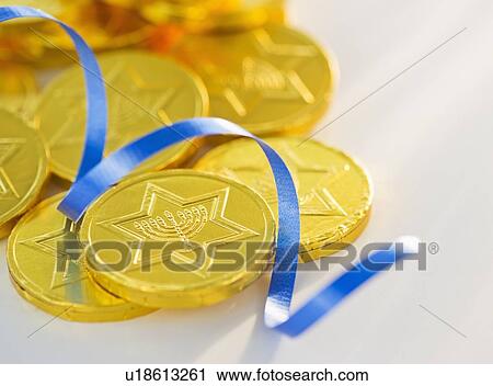 Stock Image - Studio Shot of chocolate coin and blue ribbon. Fotosearch