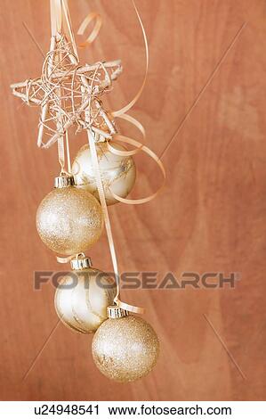 Stock Image - Studio shot of gold Christmas ornaments. Fotosearch