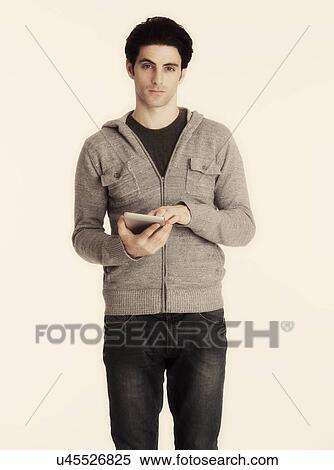 Studio shot of man holding digital tablet View Large Photo Image Stock Photography - Studio shot of man holding digital tablet. Fotosearch