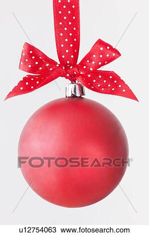 Studio shot of red Christmas ornament hanging on red spotted ribbon View Large Photo Image Stock Image - Studio shot of red Christmas ornament hanging on red spotted ribbon. Fotosearch