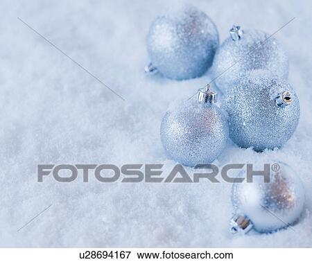 Stock Photo - Studio shot of silver Christmas ornament on snow. Fotosearch