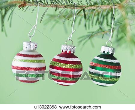 Studio shot of striped Christmas ornaments hanging on Christmas tree View Large Photo Image Stock Photo - Studio shot of striped Christmas ornaments hanging on Christmas tree. Fotosearch